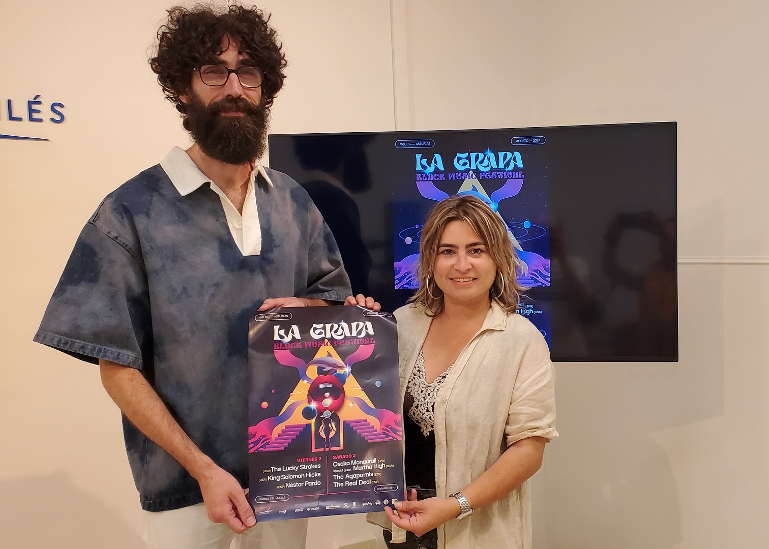 Víctor Velasco y Sara Retuerto sostienen el cartel anunciador de La Grapa Black Music Festival