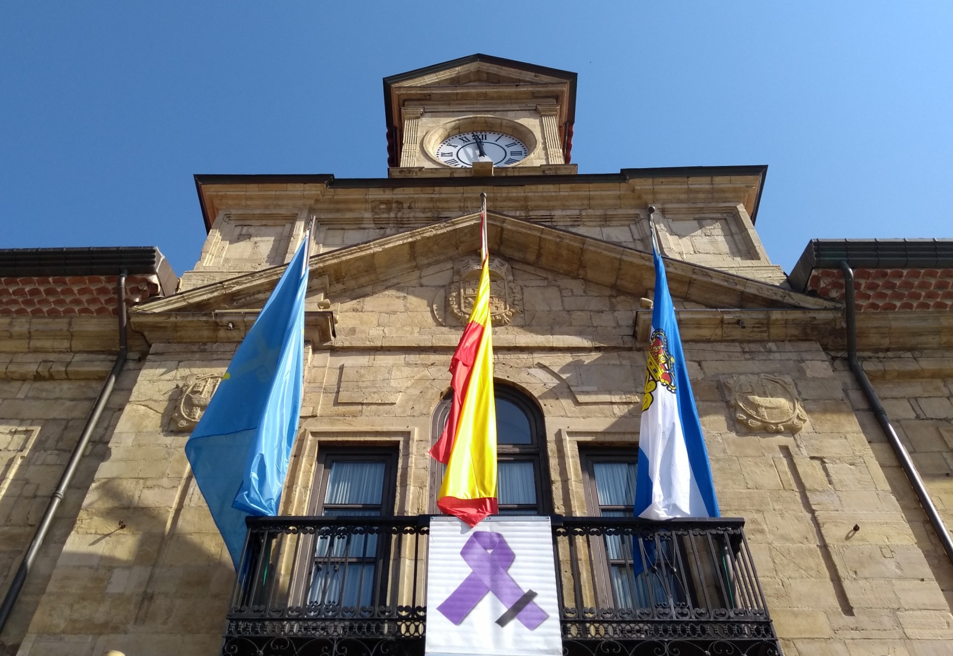 Fachada del Ayuntamiento de Avilés con lazo morado contra la violencia de género